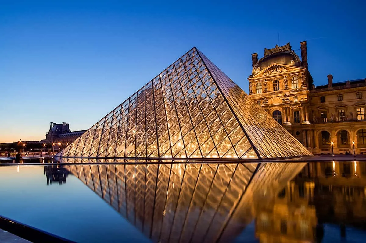 The Louvre pyramid and a Seine cruise boat on a first-day itinerary