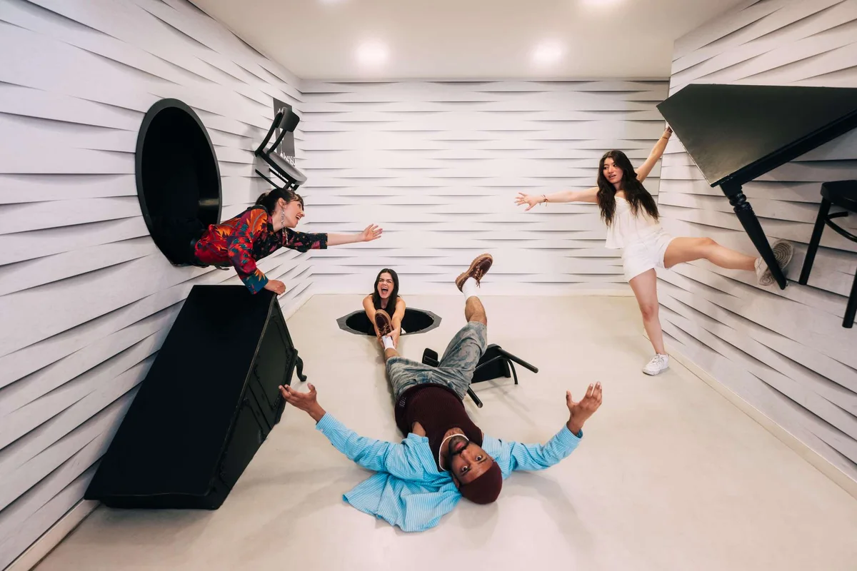 Visitors in a gravity-defying illusion room at the Paradox Museum, an interactive museum in Paris